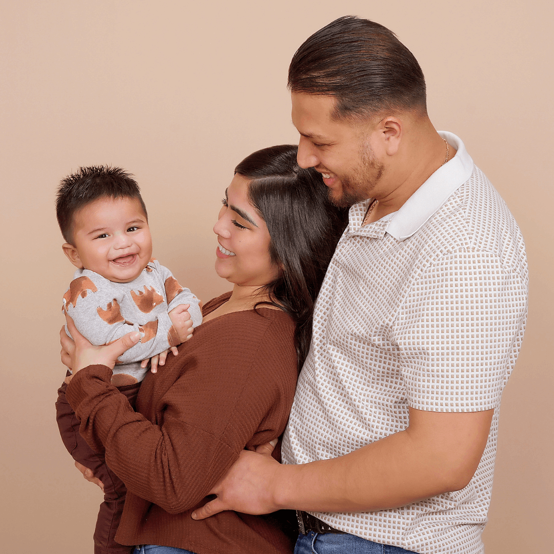 Family of 3 posing for professional pictures.
