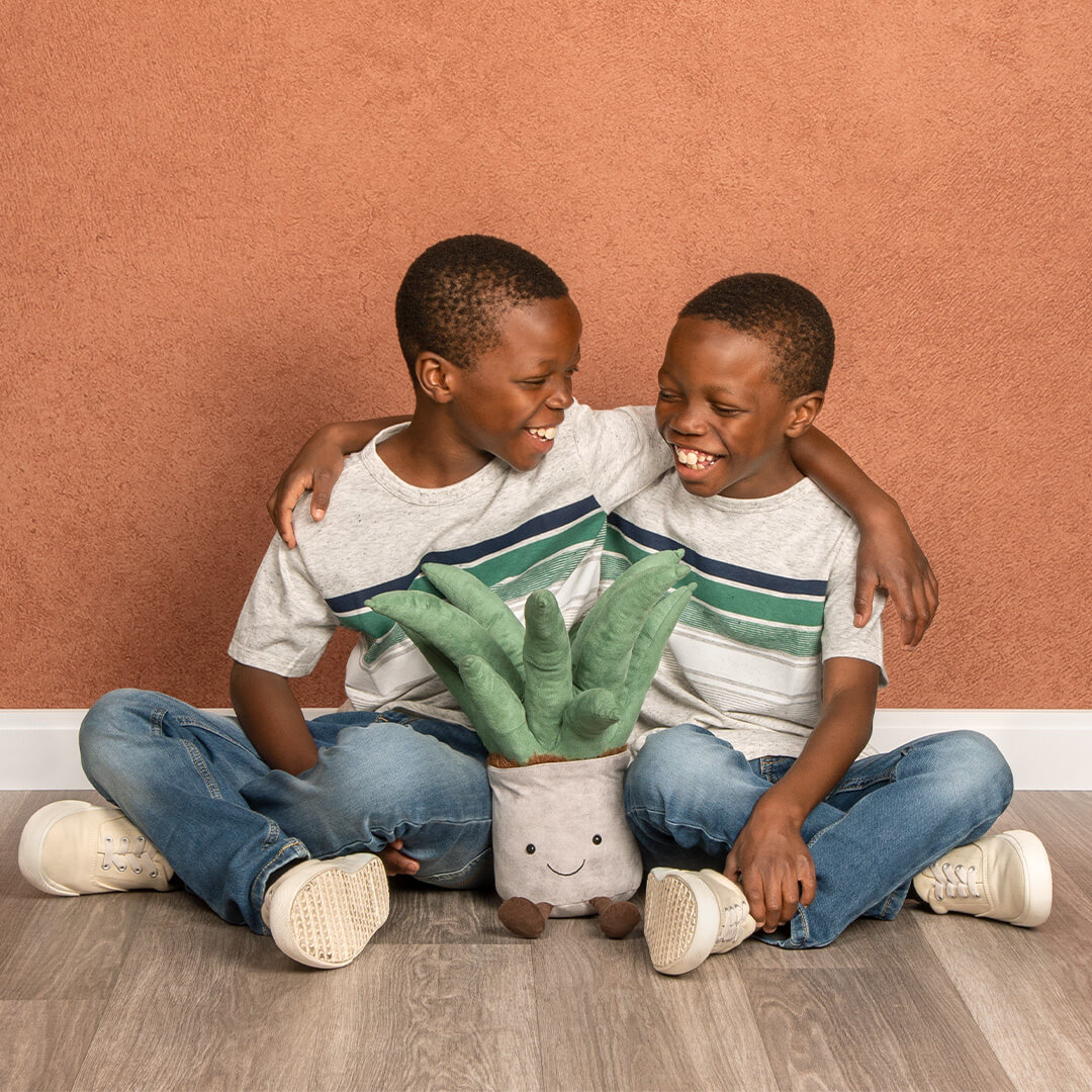 Brothers posing on the floor with props on Sienna background