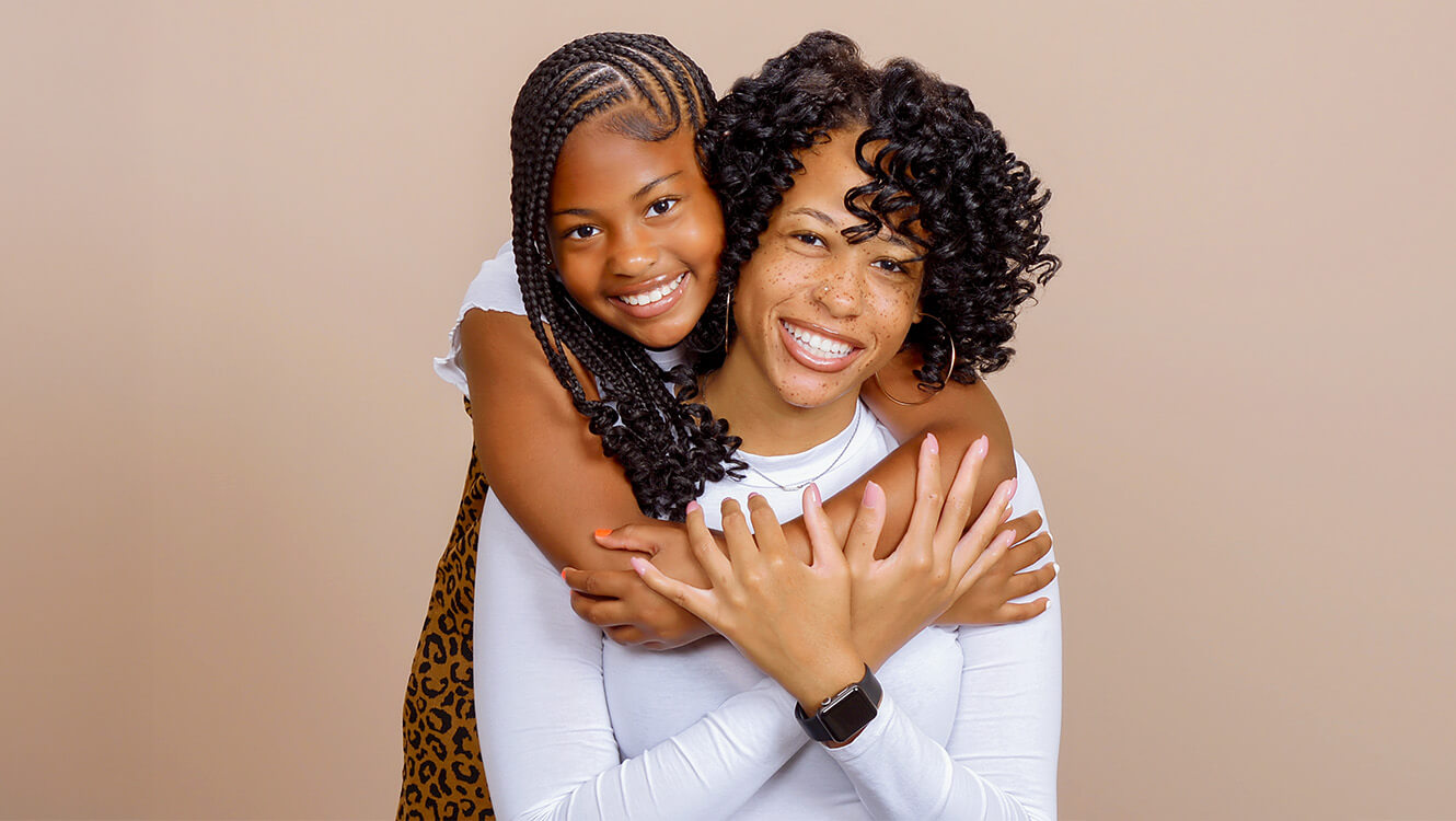 Mom and daughter hugging for a Mother's Day photo session at JCPenney Portraits.