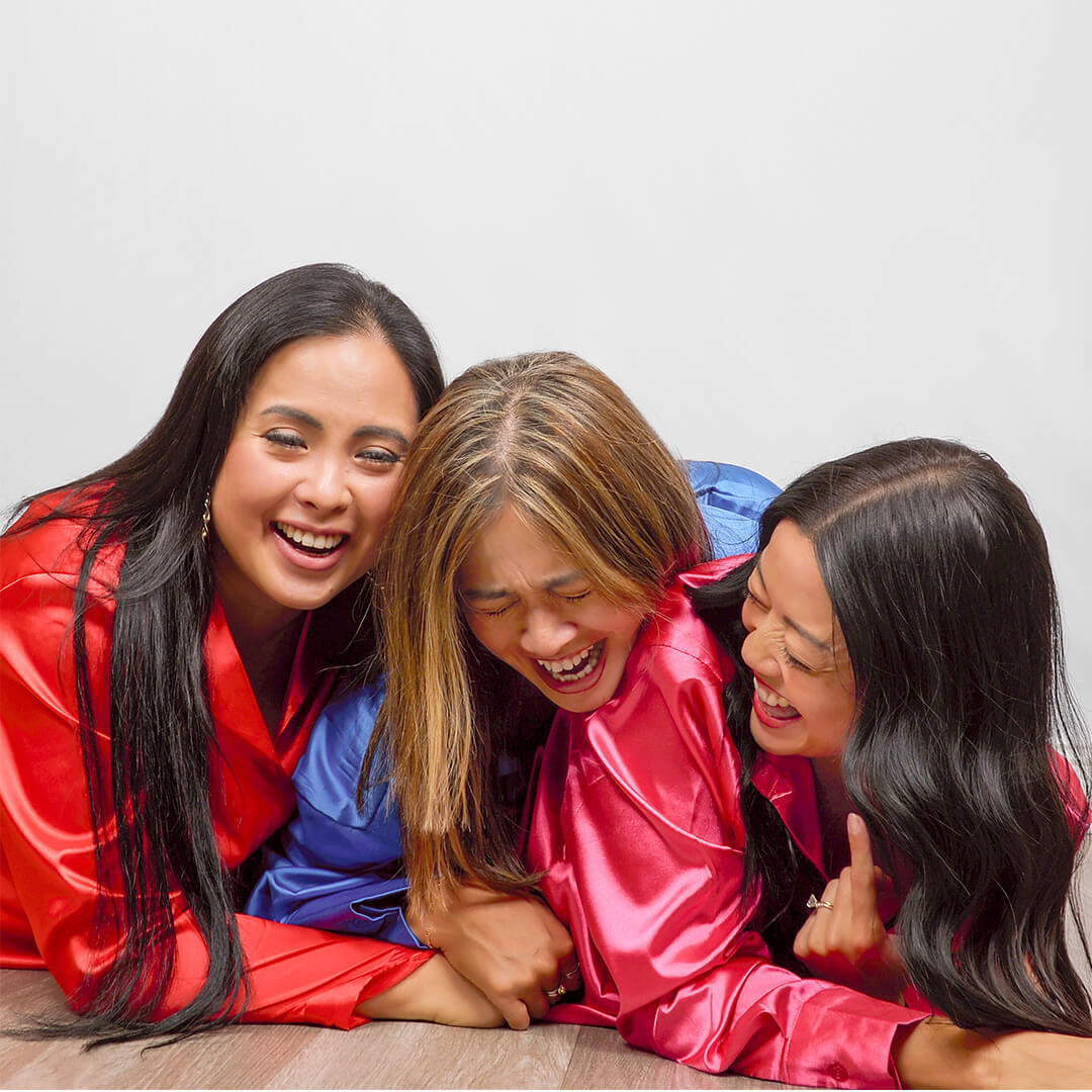 Three women in satin pajamas posing for best friend photos