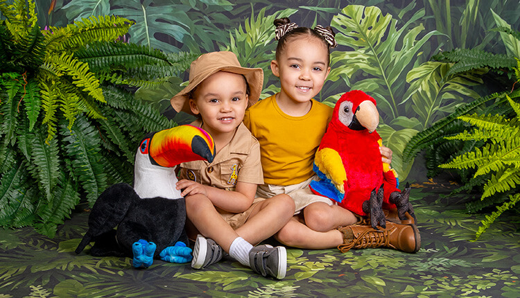 Brother and sister posing with bird props for safari photography