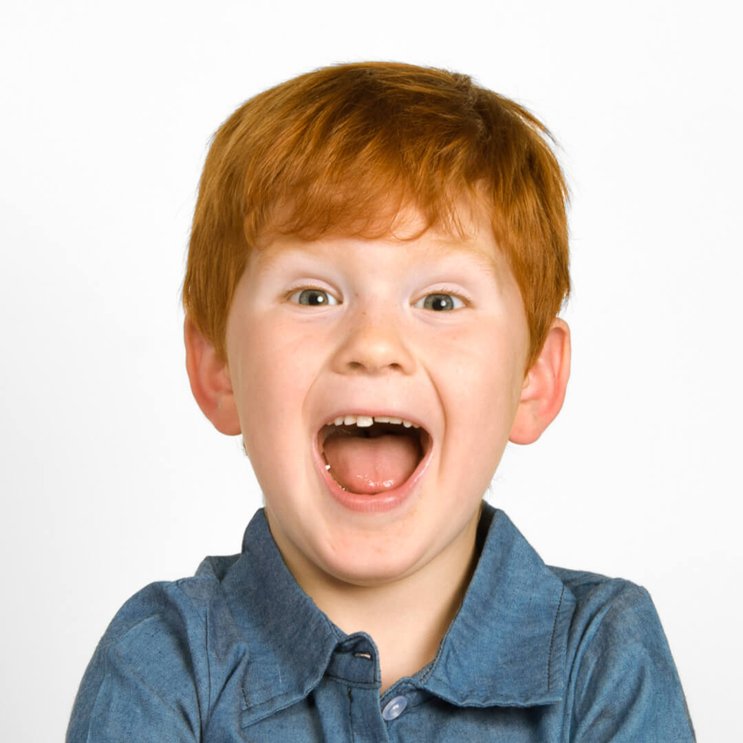 Young boy posing for candid photos on a white background.