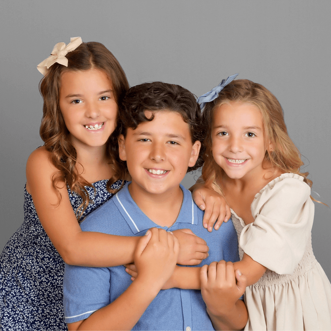 Three siblings posing for pictures at JCPenney Portraits.