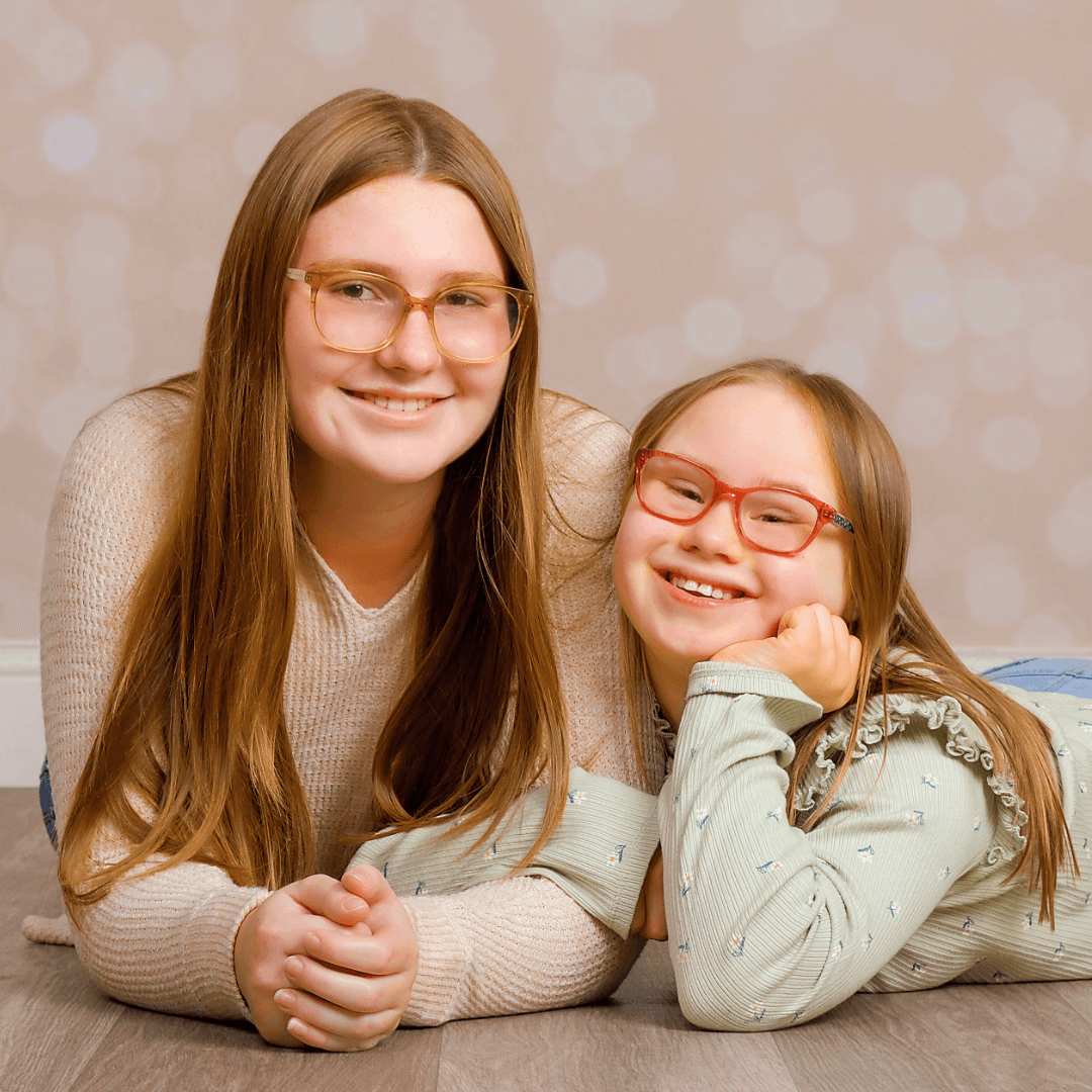 Sisters posing for pictures on a shimmer background.