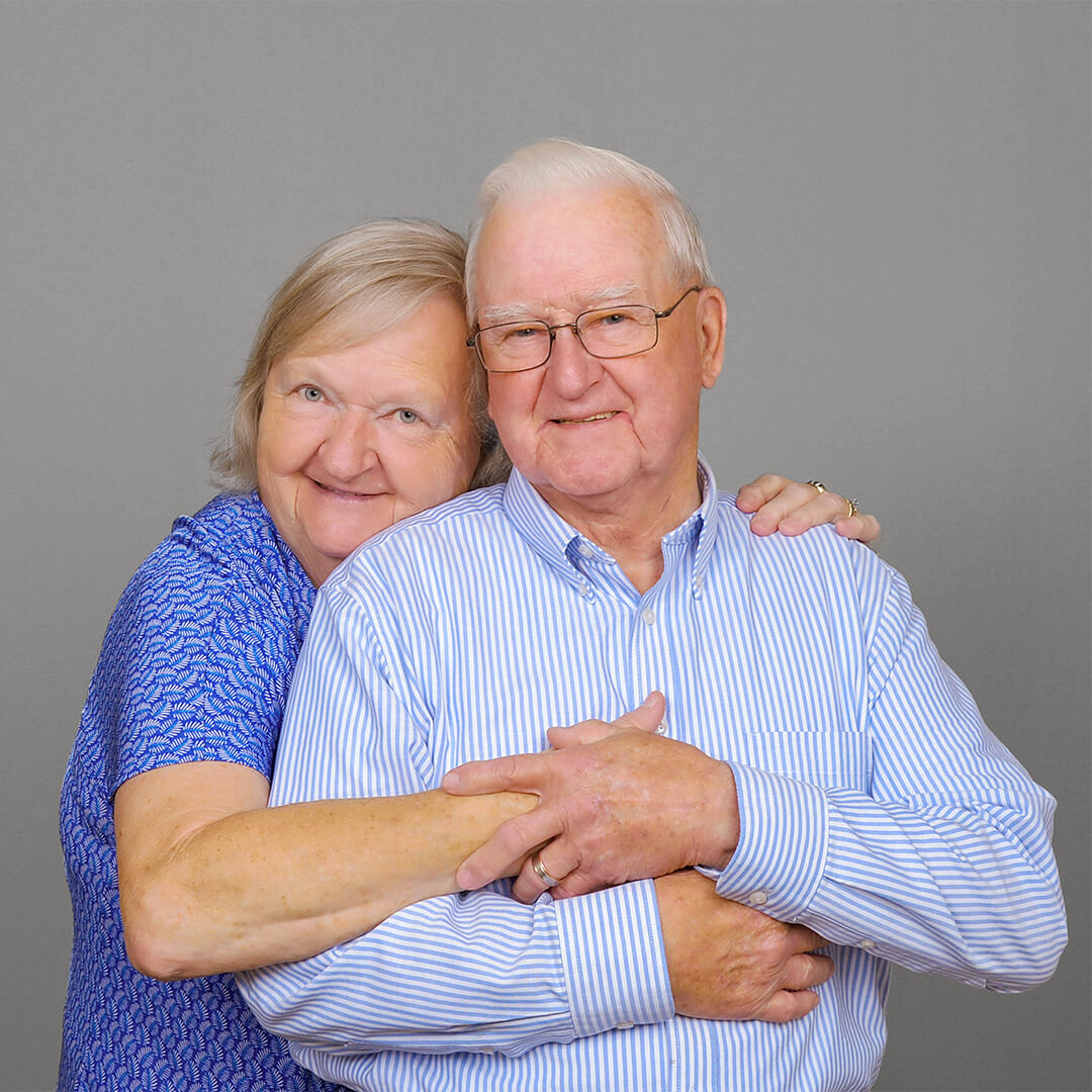 Elderly couple embracing for photos at JCPenney Portraits.