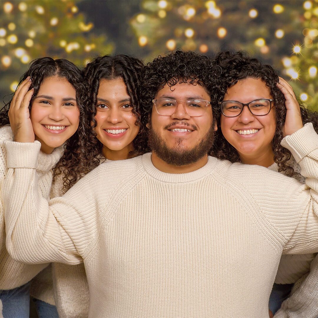 Friends smiling for awkward Christmas photos at JCPenney Portraits.
