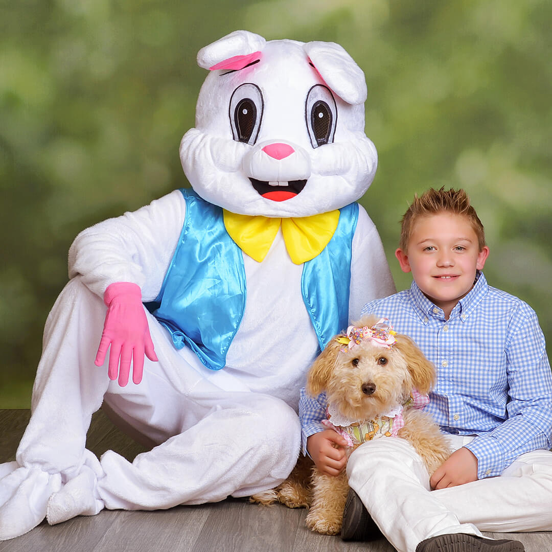 A boy and his dog taking Easter Bunny pictures.